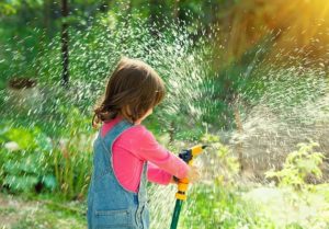 Girl spraying garden hose