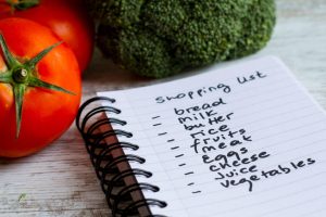 Grocery list near vegetables. Grocery shopping mistakes