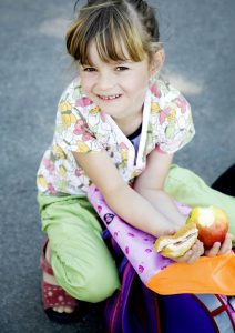 Girl holding food. Packed lunch.
