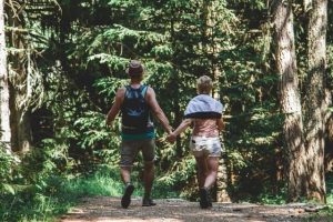 Man and woman walking in forest.